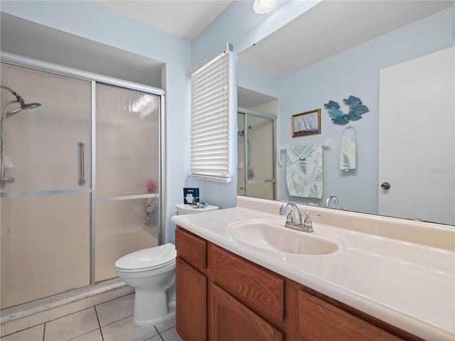 bathroom with tile patterned flooring, vanity, a shower with door, and toilet