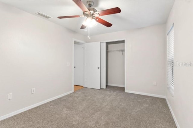 unfurnished bedroom with ceiling fan, light colored carpet, and a closet