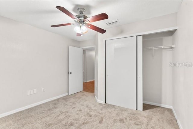 unfurnished bedroom featuring light carpet, ceiling fan, and a closet