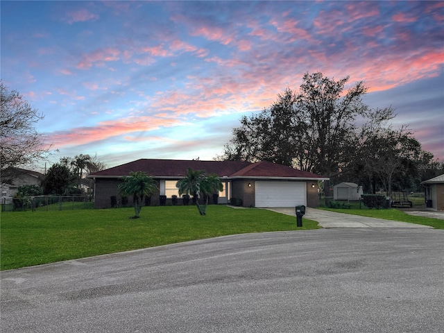 ranch-style home with a garage and a lawn