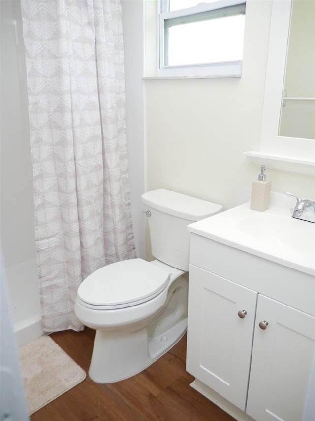 bathroom with vanity, wood-type flooring, toilet, and walk in shower