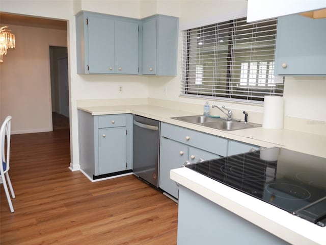 kitchen with blue cabinets, sink, stainless steel dishwasher, black electric stovetop, and hardwood / wood-style floors