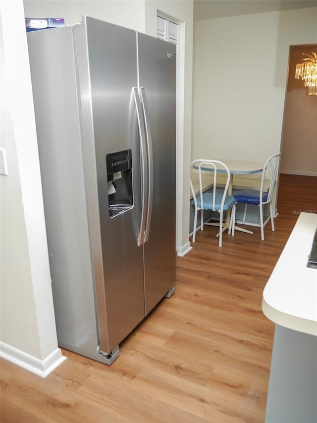 kitchen with stainless steel fridge with ice dispenser and light hardwood / wood-style flooring