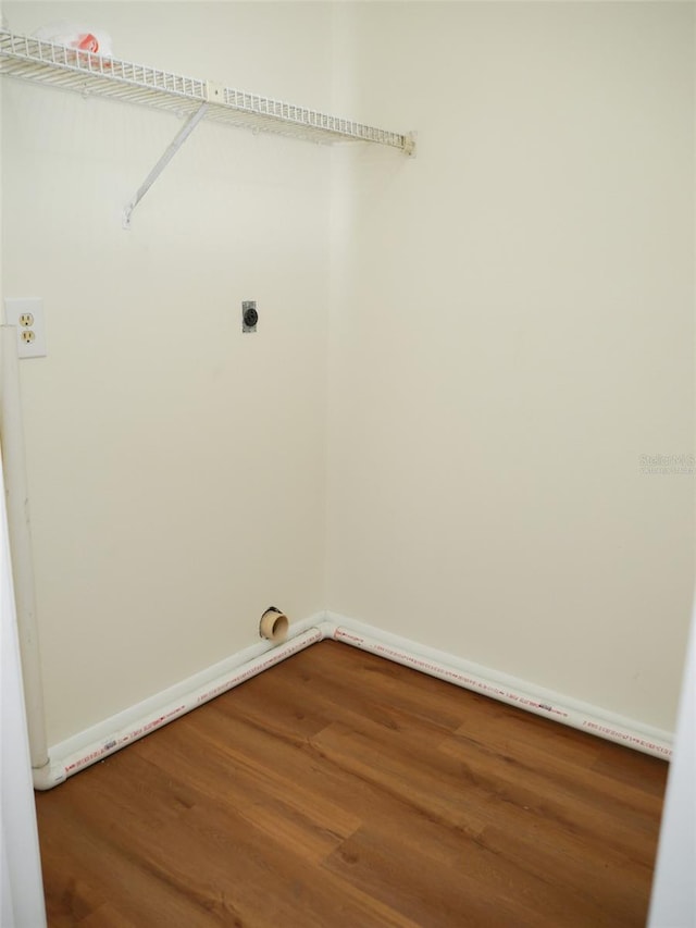 clothes washing area featuring hardwood / wood-style flooring and hookup for an electric dryer