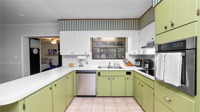 kitchen featuring sink, appliances with stainless steel finishes, backsplash, white cabinets, and kitchen peninsula