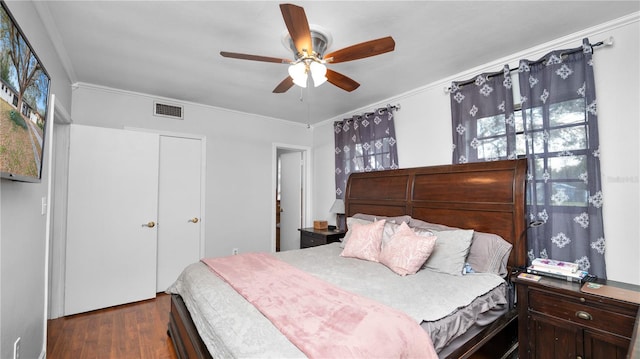 bedroom with ornamental molding, dark hardwood / wood-style floors, and ceiling fan