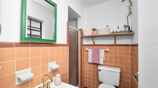 bathroom featuring tile walls and toilet