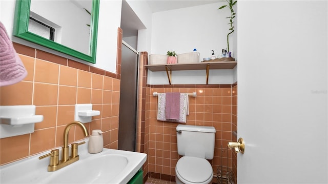 bathroom with sink, tile walls, and toilet