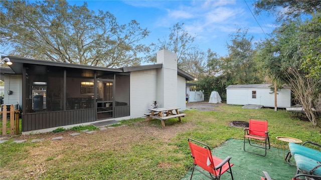 view of yard with a sunroom and a storage shed