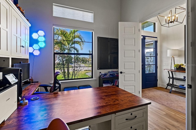 home office with a notable chandelier and light wood-type flooring