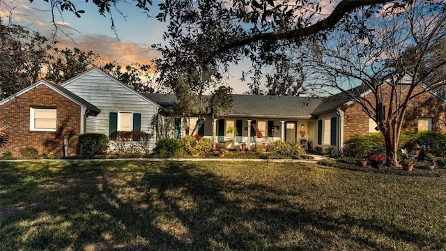 single story home with a yard and covered porch