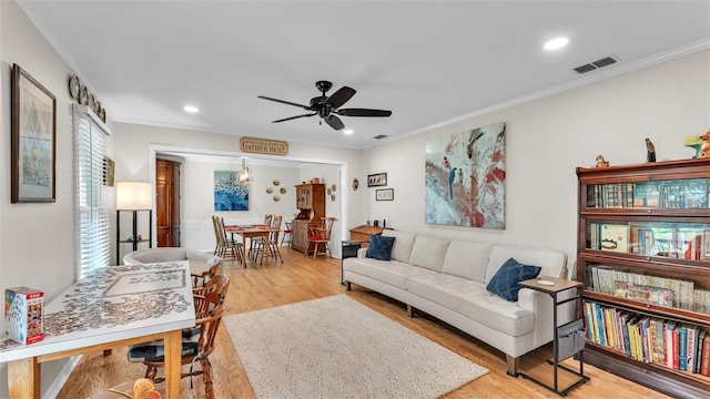 living room featuring crown molding, light hardwood / wood-style flooring, and ceiling fan