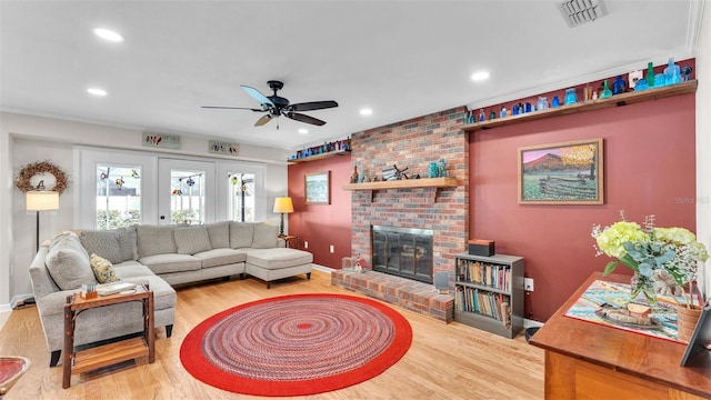 living room with hardwood / wood-style floors, a fireplace, and ceiling fan