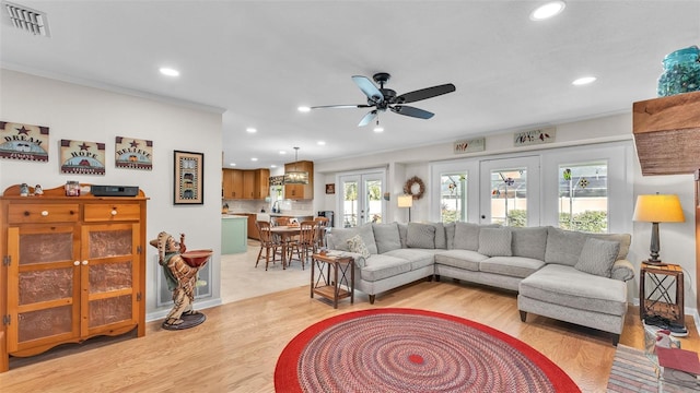 living room with crown molding, light hardwood / wood-style floors, french doors, and ceiling fan