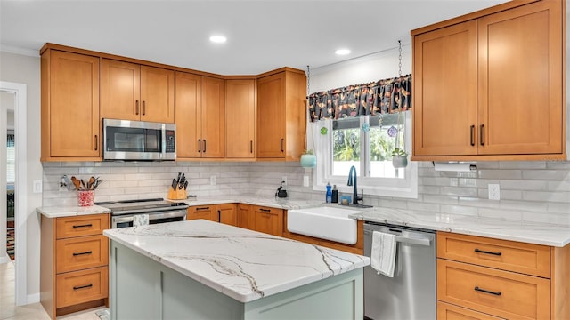 kitchen with sink, decorative backsplash, a center island, stainless steel appliances, and light stone countertops