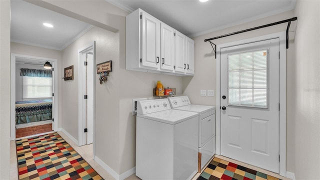 laundry room with cabinets, crown molding, and separate washer and dryer