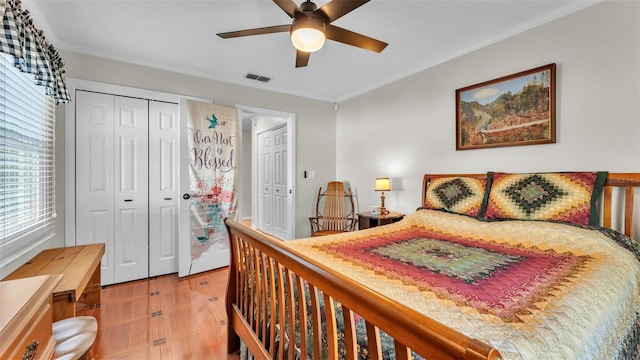 bedroom with multiple closets, ornamental molding, and ceiling fan