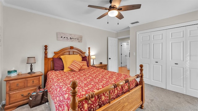 carpeted bedroom with crown molding, ceiling fan, and a closet