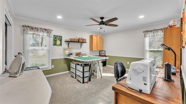 carpeted home office featuring crown molding and ceiling fan