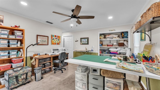 carpeted home office featuring crown molding and ceiling fan