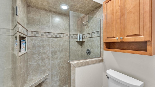 bathroom featuring a tile shower and toilet