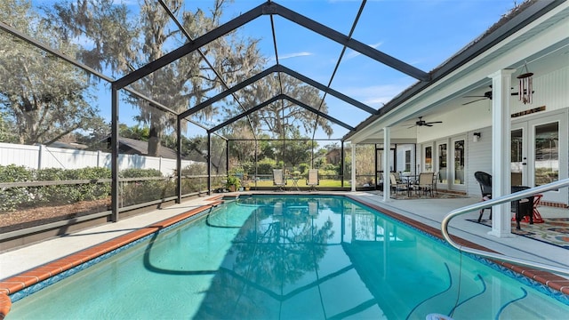 view of swimming pool featuring a patio area, french doors, ceiling fan, and glass enclosure