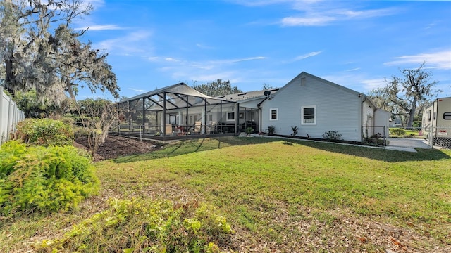 rear view of property featuring glass enclosure and a lawn