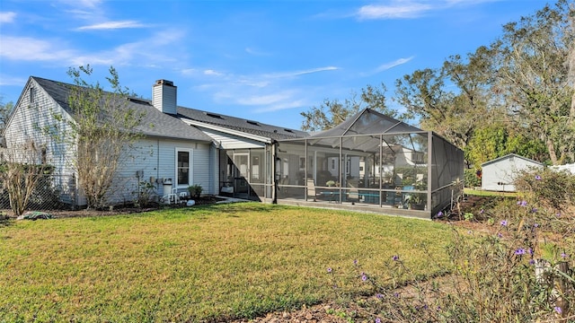 back of house featuring a yard and a lanai