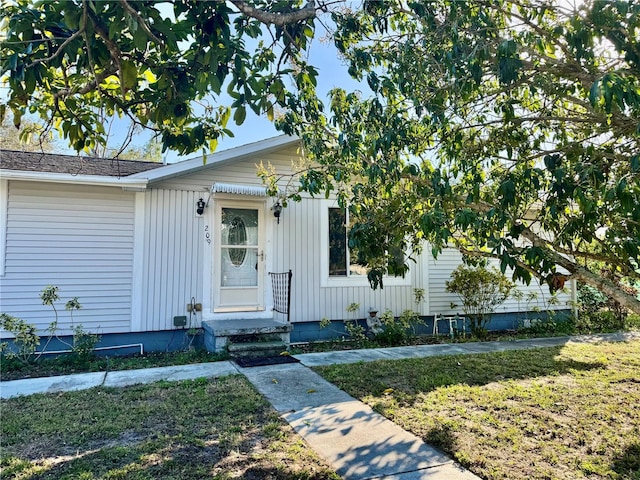 view of front of home featuring board and batten siding and a front lawn