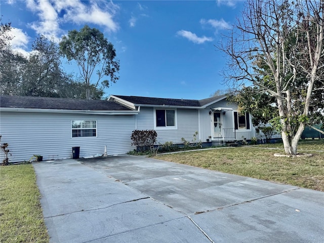 ranch-style house featuring driveway and a front lawn