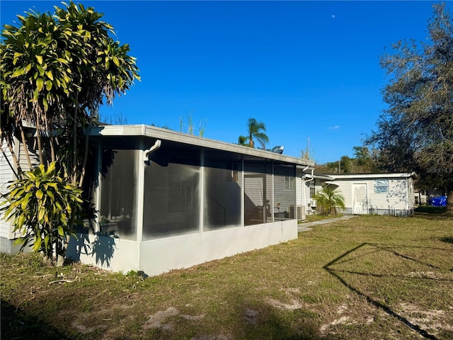 view of side of property with a sunroom and a yard