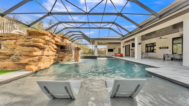 view of swimming pool featuring ceiling fan, pool water feature, glass enclosure, and a patio area