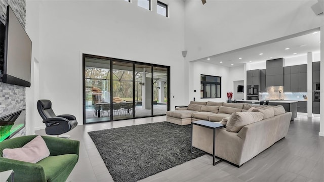 living room with a towering ceiling and a stone fireplace