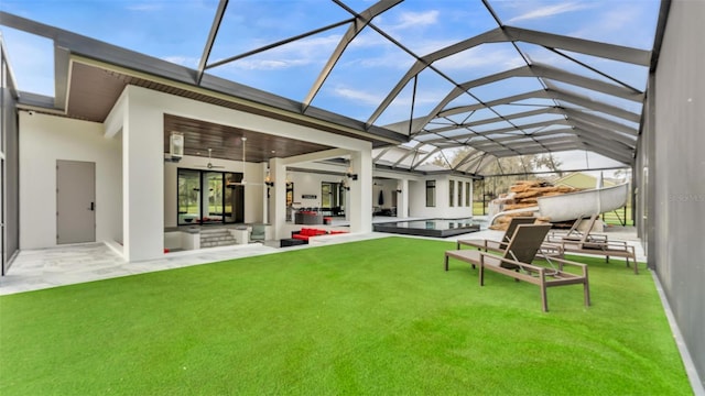 rear view of house featuring a yard, a patio area, ceiling fan, and glass enclosure