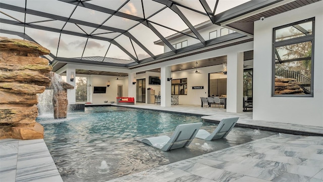 view of pool with pool water feature, a lanai, ceiling fan, and a patio area