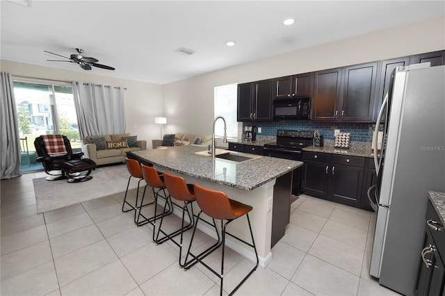 8680 Falling Blue Pl, Riverview, FL 33578 - kitchen featuring black appliances, a sink, open floor plan, a breakfast bar area, and healthy amount of natural light