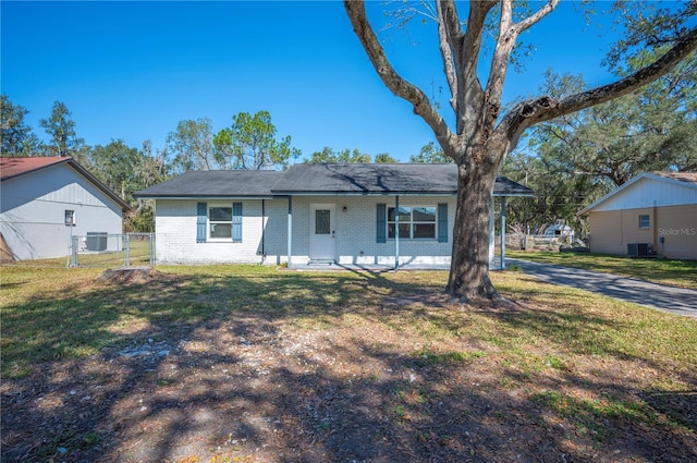 ranch-style house featuring a front yard and cooling unit