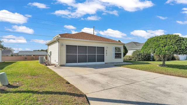 ranch-style house with a garage, a front lawn, and central air condition unit