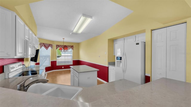 kitchen featuring sink, white appliances, a center island, and white cabinets