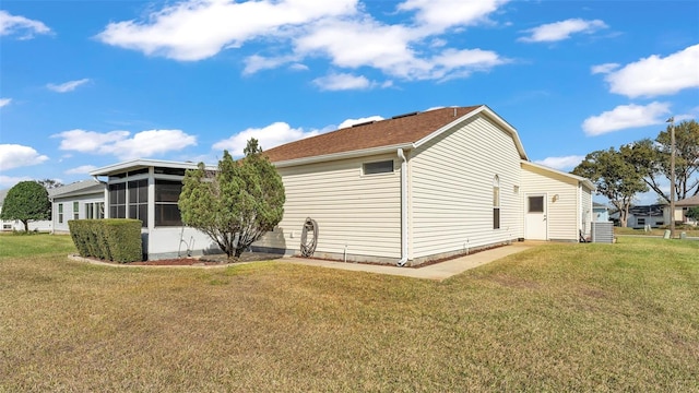 view of side of home with a yard and a sunroom