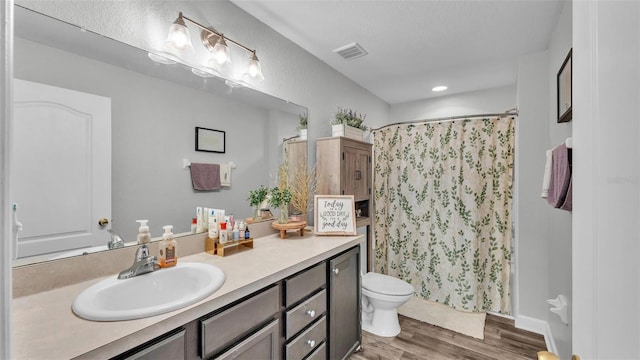 bathroom with wood-type flooring, vanity, and toilet