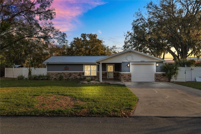 ranch-style home with a garage and a lawn