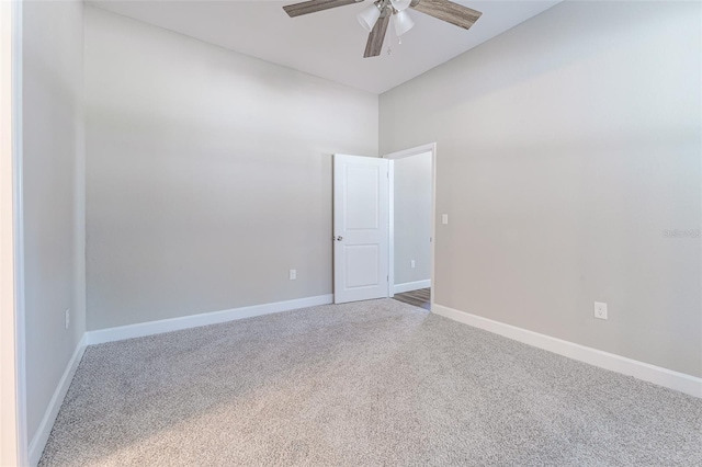 carpeted spare room featuring ceiling fan