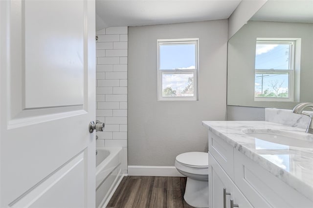 full bathroom with vanity, toilet, tiled shower / bath combo, and hardwood / wood-style floors