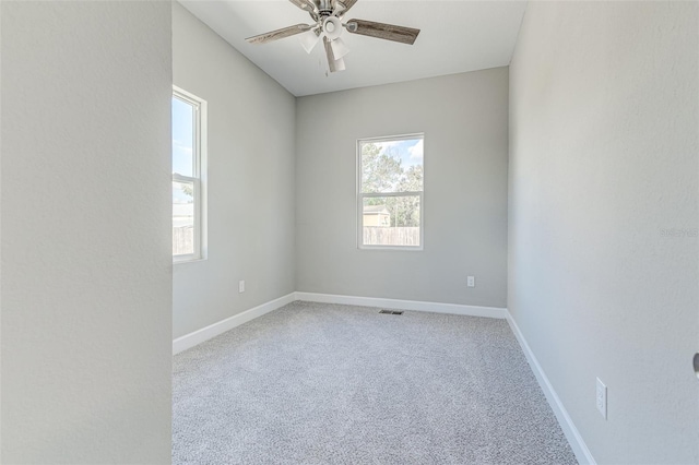 carpeted empty room featuring ceiling fan and a healthy amount of sunlight