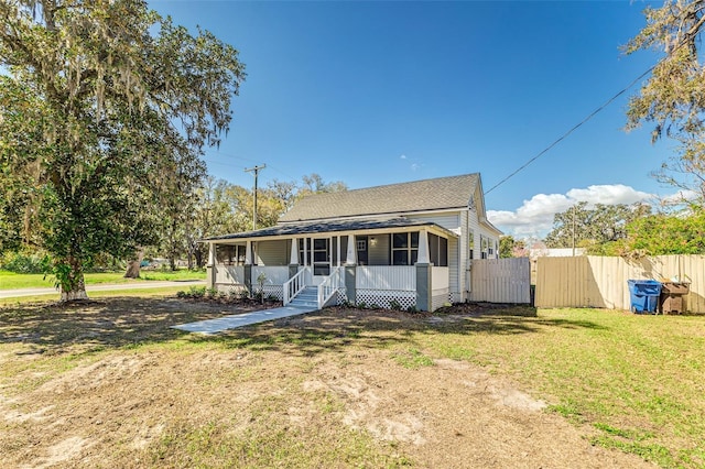 bungalow-style home featuring a front lawn and covered porch