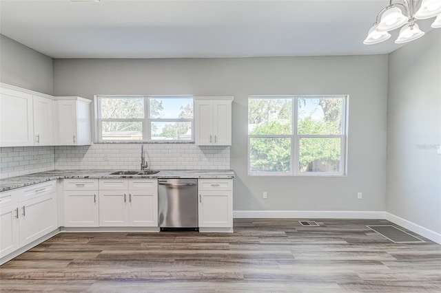 kitchen with light stone counters, sink, white cabinets, and dishwasher