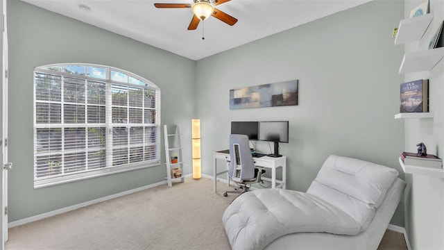 carpeted home office with ceiling fan and baseboards