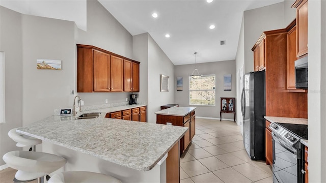 kitchen with black appliances, a sink, a center island, a peninsula, and brown cabinetry