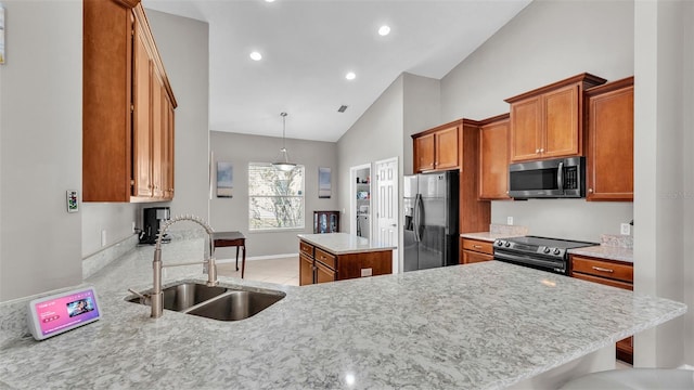 kitchen featuring brown cabinetry, a peninsula, a sink, appliances with stainless steel finishes, and a center island